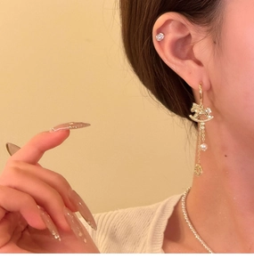 Detail van elegante schommelpaard parel oorbellen met zirkoon op het oor van model