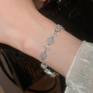 Détail d'un bracelet floral en zircon avec cristal goutte d'eau bleu au poignet