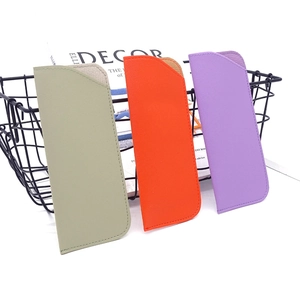 Close-up of three PU leather eyewear pouches in olive, orange, and purple hues