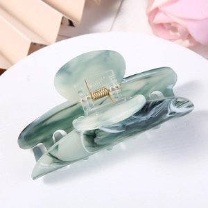 Elegant marble pattern acetate hair claw clip with golden metal spring on white stand