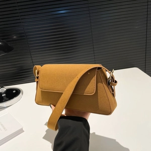 Close-up of caramel suede shoulder bag showing matte texture and gold metal hardware