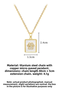 Detailed view of gold square cat paw pendant with zirconia and shell on titanium chain