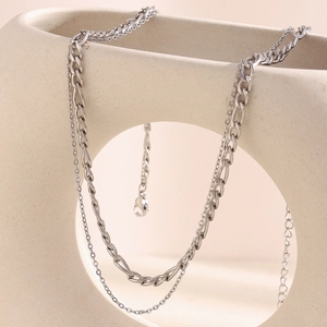 Close-up of double-layer silver stainless steel Figaro and cable chain necklace