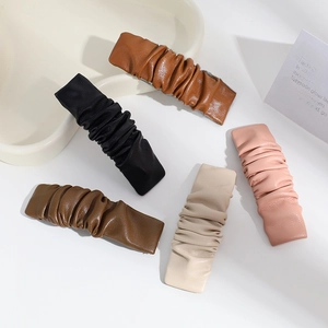 Minimalist pleated PU leather hair clips in assorted neutral colors on a white background