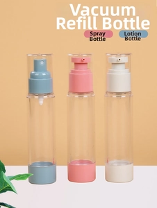 Three travel vacuum pump bottles for spray and lotion with pistons on orange background