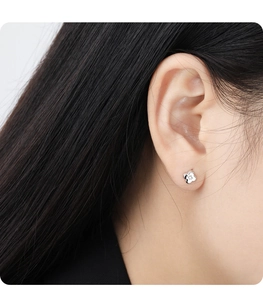 Close-up of minimalist S925 sterling silver four-leaf clover stud earrings on ear model