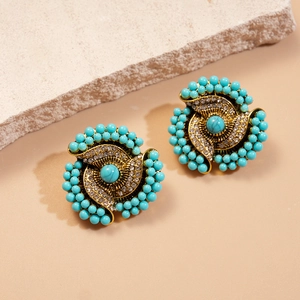 Vintage gold-plated floral earrings with turquoise beads and crystals on a stone plate