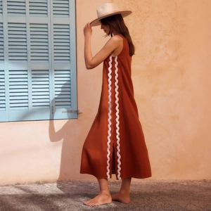 Rust red sleeveless midi dress with white scalloped trim and side slit detailing