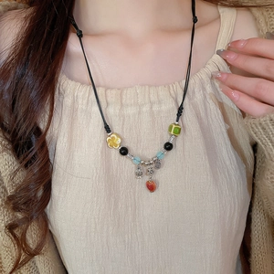 Detailed shot of ethnic ceramic beaded necklace with floral accents and adjustable cord