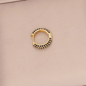 Detail of 18K gold-plated earring featuring micro-pave black cubic zirconia stones