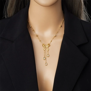 Collier nœud doré élégant avec zircons en goutte d'eau porté par un mannequin chic