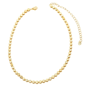 Detail of gold tennis necklace showing yellow zircon stones and heart-shaped chain extender