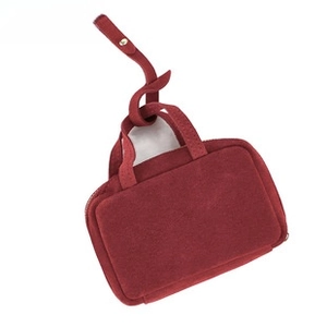 Macro detail of wine red suede leather mini handbag with zip closure and top handles
