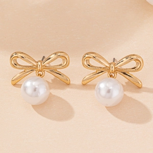 Detailed view of elegant gold bow earrings featuring a round white hanging pearl