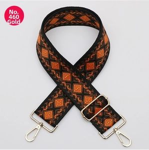 Close-up of ethnic geometric orange and black bag strap with gold metal swivel hooks