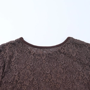 Detail of coffee brown lace dress showing intricate floral patterns and round neckline
