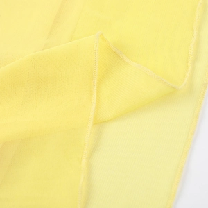 Vue macro du tissu en maille jaune montrant les coutures fines et les détails de texture