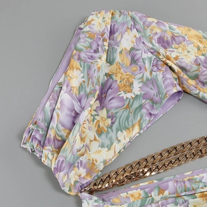 Detail of floral printed fabric with a stylish woven gold chain strap decoration