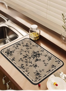 Detail of French style kitchen drainage mat with black floral patterns on khaki background
