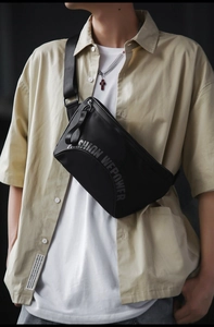 Détail de la bandoulière réglable et du tissu en nylon imperméable du sac bandoulière noir