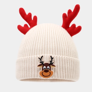 Close-up of knit Christmas hat with red reindeer antlers and cute reindeer embroidery
