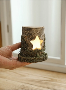 Close-up of star-shaped wooden lamp with warm LED light and natural bark texture details