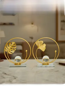 Detailed view of golden ginkgo and monstera leaf metal ornaments with crystal ball base