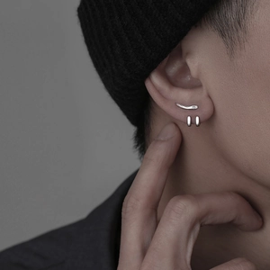 Close-up of minimalist silver curved ear hook and small hoop earrings on male model