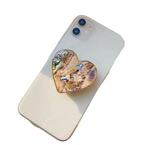 Iridescent abalone shell heart phone grip with gold electroplated edge on white phone