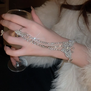Close-up of sparkling butterfly crystal ring-bracelet set on model's hand with layered chains