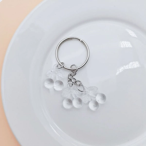 Detail showing a transparent cherry pendant with a silver metal ring and chain