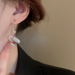 Detail of coffee cup earrings with white rhinestones and red heart gem on ear hook