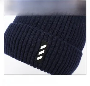 Close-up of dark blue ribbed knit beanie featuring a black rectangular striped label