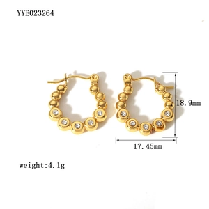 Detailed view of 18K gold plated eye-shaped earrings with zircon and beaded texture