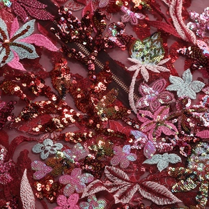 Detail of red floral embroidery with heavy sequins on mesh fabric for elegant dresses