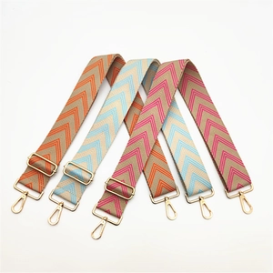 Close-up of wide herringbone pattern straps with golden metal buckles and swivel hooks