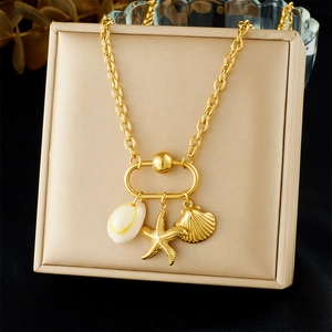 Detail of gold seashell and starfish pendants on a necklace inside a jewelry box