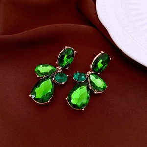 Close-up of green water drop crystal earrings with gold plating and faceted gemstones