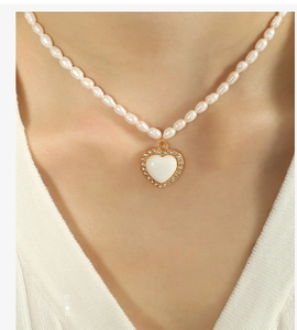 Dettaglio di un'elegante collana di perle con un pendente a forma di cuore con diamanti