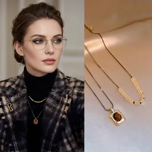 Macro view of 18k gold plated necklace with oval tiger eye stone pendant and vintage chain