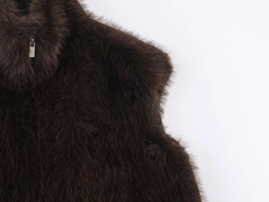 Detailed macro view of dark brown faux fur texture and silver zipper on stand collar vest