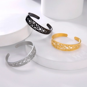 Dettaglio dei motivi a nodo celtico su bracciali in acciaio inossidabile oro, argento e nero