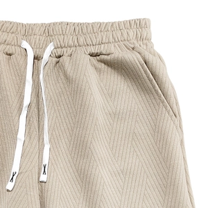 Détail du short en maille jacquard beige avec taille élastique, cordon de serrage et poches