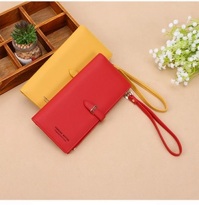 Detail view of red and yellow long PU leather wallets with wrist straps and zip closure