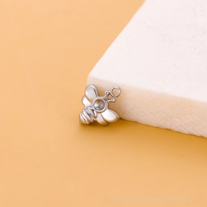 Vue macro d'un pendentif abeille en acier inoxydable avec insert sur pierre blanche
