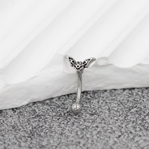 Detailed view of stainless steel bat eyebrow ring with curved barbell and polished bead