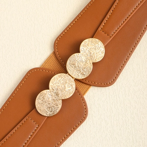 Detail of wide brown elastic belt with interlocking textured gold metal discs buckle