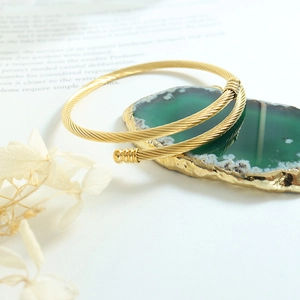 Minimalist twisted cable gold open cuff bracelet on elegant green agate stone display