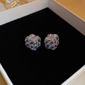 Macro view of geometric cube earrings with sparkling zircons in a premium jewelry box