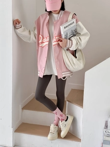 Close-up of pink heart pattern socks paired with white sneakers on wooden stairs